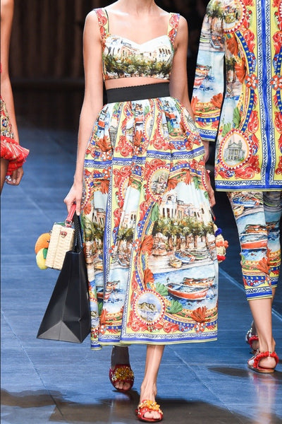 girl on runway wearing multi coloured print crop top and long skirt with bare midriff.