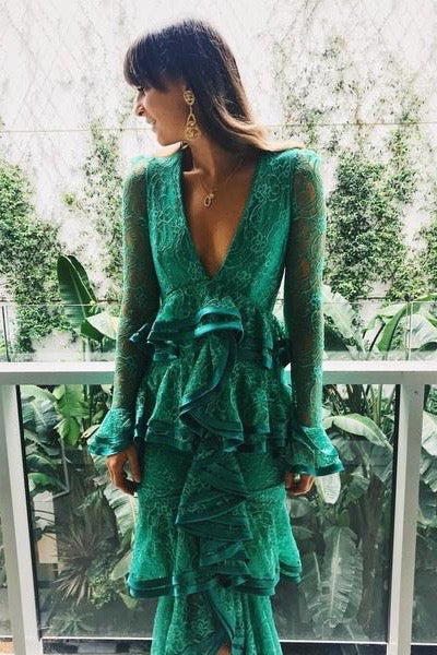 Girl with head turned wearing long sleeve full lace emerald green dress. V-Neckline and mid length ruffle skirt.
